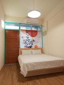 a small bedroom with a bed and a door at 老宅小巷6人包棟民宿 in Taitung City