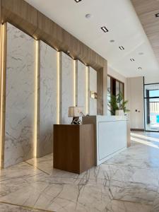 a lobby with a reception desk and marble walls at NEOS HOTEL in Astana