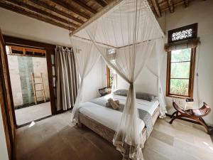una camera da letto con un letto con zanzariera di Two Smiling Buddhas a Jasri