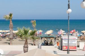 una playa con sillas y sombrillas y el océano en Tuck Inn, en Lárnaca