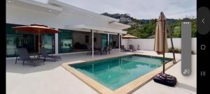 a house with a swimming pool and an umbrella at kadena villa in Koh Samui 
