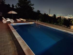 a swimming pool at night with a view of the city at Bungalovi Lana in Sarajevo