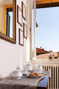 a table with a plate of croissants and a mirror at Residenza Palazzo Marchesini in Bologna +22 photos