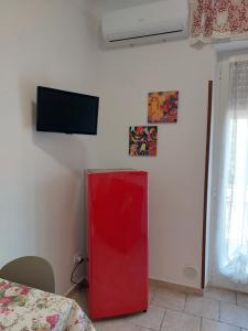 un armario rojo en una habitación con TV en la pared en Marina Apartments, en Taranto