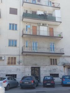 un edificio con coches estacionados frente a él en Marina Apartments, en Taranto