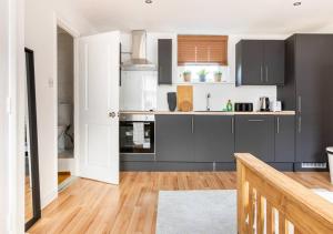 a kitchen with gray cabinets and a wooden floor at Modern Studio Apartment In Shoreditch in London