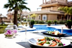 a table with a plate of food and a glass of wine at 5* Serviced Apartment Marbella in Marbella
