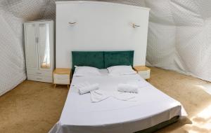 a bedroom with a white bed with two pillows at Glamping By The Sea in Năvodari