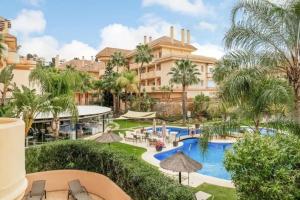 a view of a resort with a pool and palm trees at 5* Serviced Apartment Marbella in Marbella