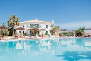 a large swimming pool in front of a house at Casa Velha Apartments - Adults friendly in Albufeira