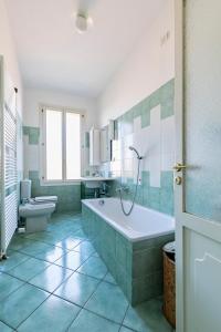 een badkamer met een bad, een toilet en een wastafel bij Residenza Palazzo Marchesini in Bologna
