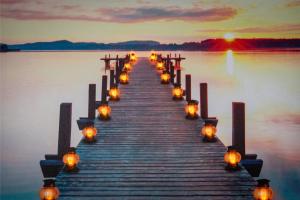 a pier with lights on the water at sunset at A home away from home - Derby in Derby