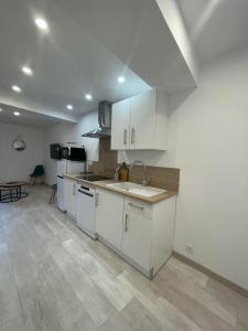 uma cozinha com armários brancos e um lavatório em 4TOAU11- Belle maison de village en plein cœur du Faubourg em Collioure