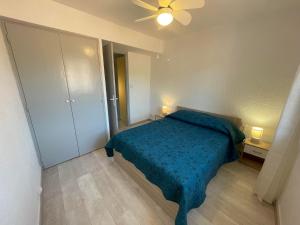 um quarto com uma cama azul e uma ventoinha de tecto em 4TOAU11- Belle maison de village en plein cœur du Faubourg em Collioure
