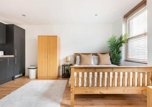 a bedroom with a wooden bed and a window at Modern Studio Apartment In Shoreditch in London