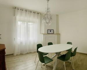 a dining room with a white table and green chairs at Terra Teatina B&B in Chieti
