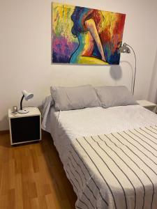 1 dormitorio con 1 cama y una pintura en la pared en Olivos Suites in 