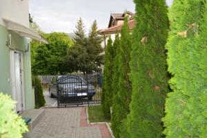 a house with a hedge fence and a bench in a yard at Beauty Apartment in Ohrid