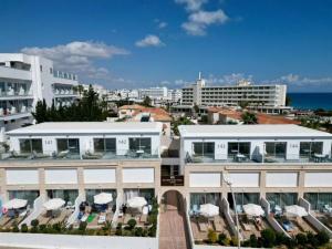 a view of a building with chairs and umbrellas at Fig Tree Island Apartment-144 in Protaras