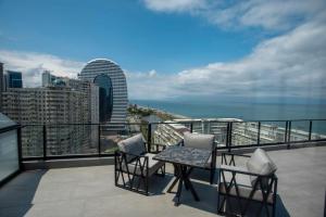 un balcón con 2 sillas y una mesa en el balcón en Gumbati Apart Hotel en Batumi