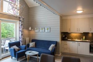 a living room with a blue couch and a kitchen at Florø Rorbu in Florø