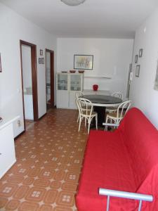 リニャーノ・サッビアドーロにあるCondominio Mareのリビングルーム(赤いソファ、テーブル付)