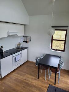 a kitchen with a black table and a table and chairs at Hólar Countryside Cabin 2 in Selfoss +6 photos