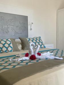 two swans made out of towels on a bed at San Raffaele Guest House in Villasimius
