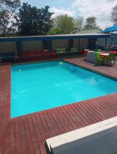 a large blue swimming pool with tables and chairs at THK Properties in Pretoria