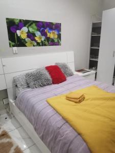a bedroom with a bed with a painting on the wall at THK Properties in Pretoria