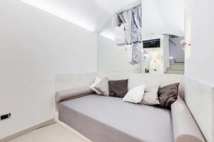 um quarto branco com um banco com almofadas em Cherì Navona em Roma