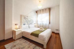 biała sypialnia z dużym łóżkiem i oknem w obiekcie Piles Garden Apartamento w mieście Gijón