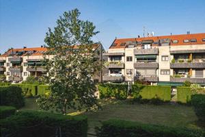 an apartment building with a tree in front of it at Piles Garden Apartamento in Gijón