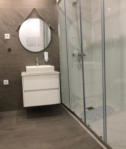 a bathroom with a shower and a sink and a mirror at Apartamento Estrela do Mar in Nazaré +16 photos