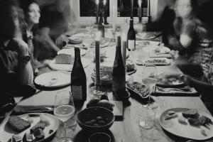 einen langen Tisch mit Weinflaschen und Teller mit Lebensmitteln in der Unterkunft Das Edith in Stuttgart