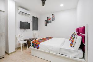 a bedroom with a bed and a desk and a tv at FabExpress VYS Inn in Pune
