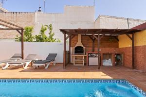 a swimming pool with a gazebo next to a house at Vivienda con piscina in Nerja