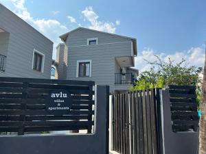 a house with a black fence in front of it at Avlu Villas & Apartments in Kemer