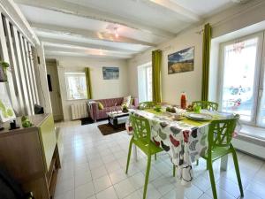 sala de estar con mesa, sillas y sofá en Gîte Pomme Verte - BY PRIMO C0NCIERGERIE, en Vonnas