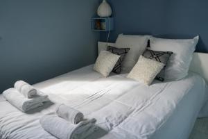 1 cama blanca grande con toallas y almohadas. en Gîte Pomme Verte - BY PRIMO C0NCIERGERIE, en Vonnas