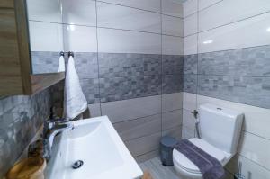 een badkamer met een wit toilet en een wastafel bij Palm home 1 in Makry Gialos