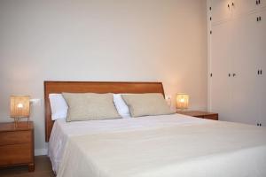 - une chambre avec un grand lit blanc et deux lampes dans l'établissement Mirador Torres de Playamar, con vistas al mar, à Torremolinos