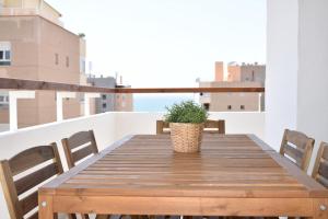 une table en bois avec une plante en pot sur un balcon dans l'établissement Mirador Torres de Playamar, con vistas al mar, à Torremolinos