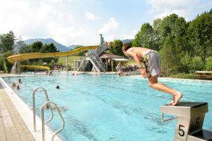 um homem de pé numa borda numa piscina em LANDHAUS JASMIN ausgezeichnet mit 4 Kristallen - FW Zinkenblick em Bad Mitterndorf
