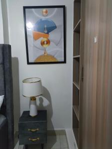 a bedroom with a lamp and a picture on the wall at Immaculate 1-Bed Apartment in Nairobi in Nairobi