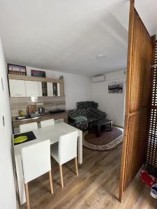een keuken en een woonkamer met een tafel en stoelen bij Apartment Hills in Neum