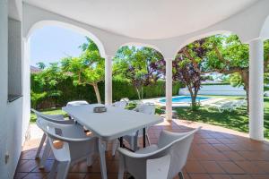 a patio with a table and chairs and a pool at Vila Tres Cales in Les tres Cales