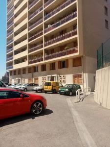 um carro vermelho estacionado em frente a um grande edifício em Appartement T4 à deux pas de la gare St Charles em Marselha