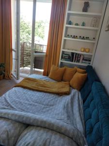 ein Schlafzimmer mit einem Bett mit einer blauen Decke in der Unterkunft Apartamencik przy Tężni w Konstancinie in Konstancin-Jeziorna