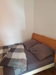 a bed with two pillows on it in a room at Biedronka- samodzielny apartament dla 3 osób z miejscem parkingowym in Sopot